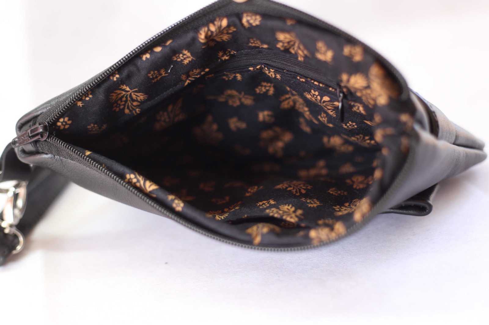 Black clutch made out of black genuine leather.