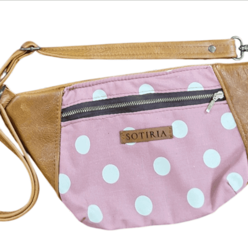 Moon bag made from tan genuine leather and pink polka dot cotton with adjustable waist strap.